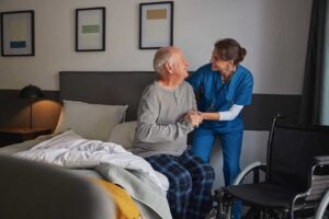 Older adult and family member discussing care plans at a kitchen table with paperwork and coffee.